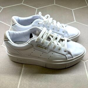 Adidas platform sneakers with gold accents.